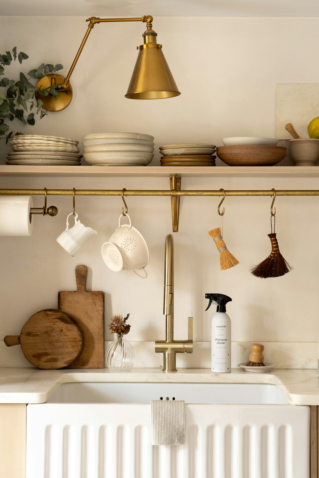 a-kitchen-with-a-white-sink-and-gold-faucet-zmuxhjmycya